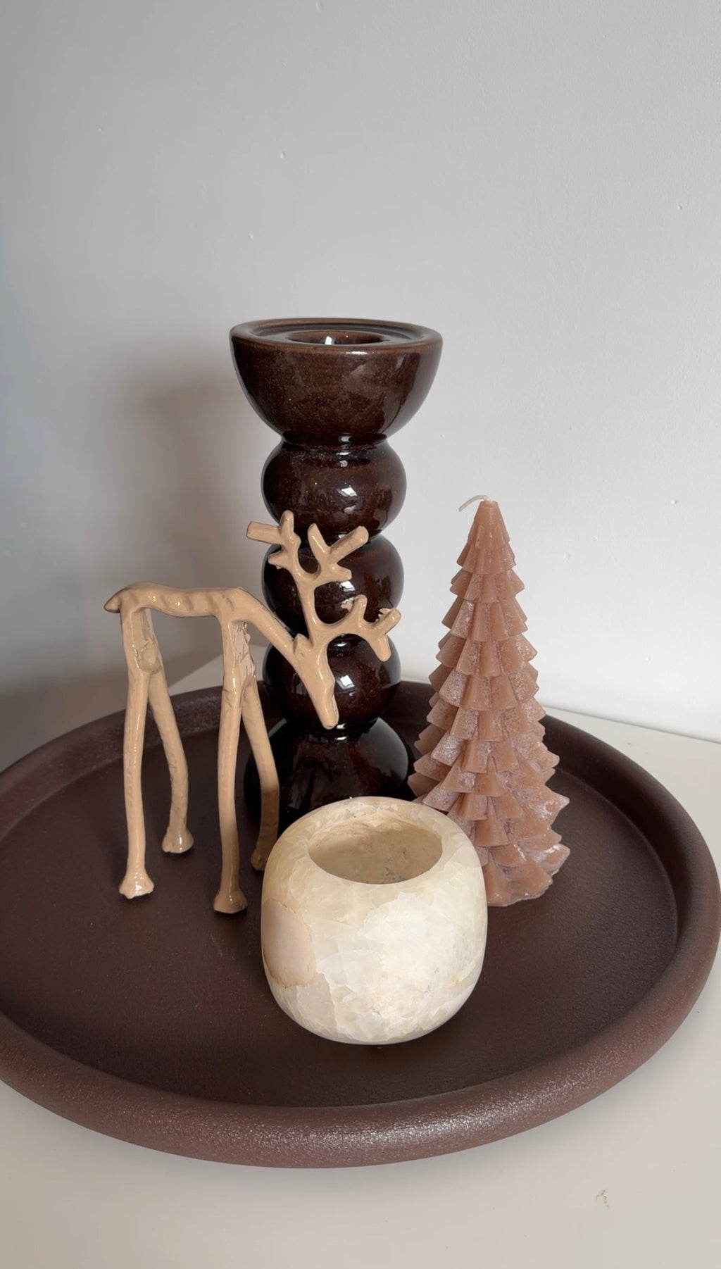 Decoratieve kerstboomkaars in beige gecombineerd met rendieren en bruine kerstdecoratie