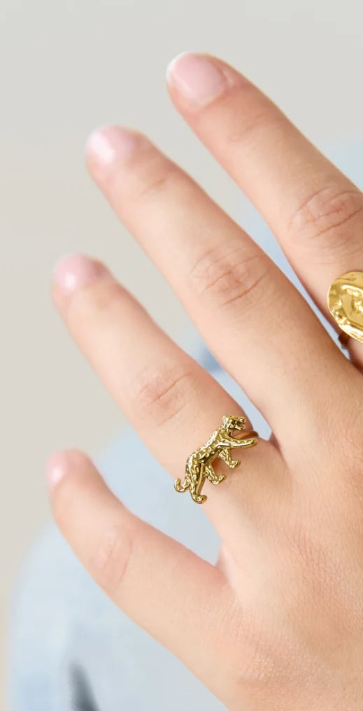 Hand met gouden panter ring gecombineerd met andere gouden sieraden – Mysa Lifestyle